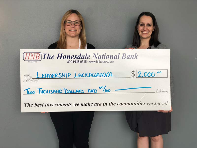 two women and a large check