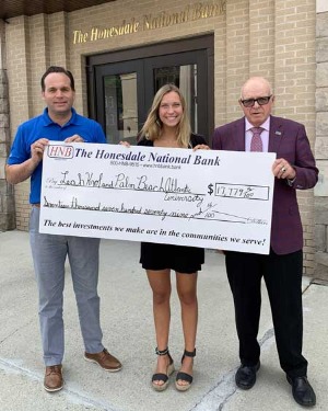 three people holding a Lemnitzer scholarship donation for Leah Krol