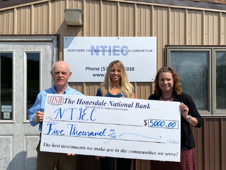 Rick Soden and Michelle Kowalewski holding check donation for the NTIEC