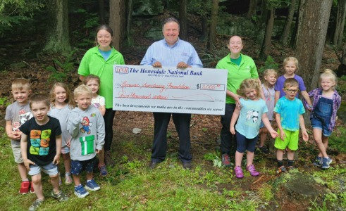 class of children at the Lacawac Sanctuary holding a check donation