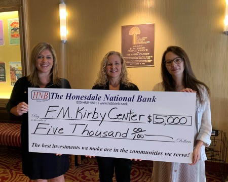 three people holding check donation for F.M. Kirby Center