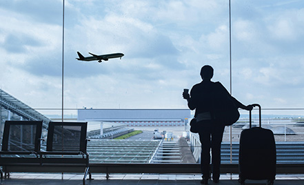 woman looking out large window at airplane