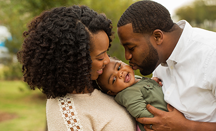 couple kissing baby