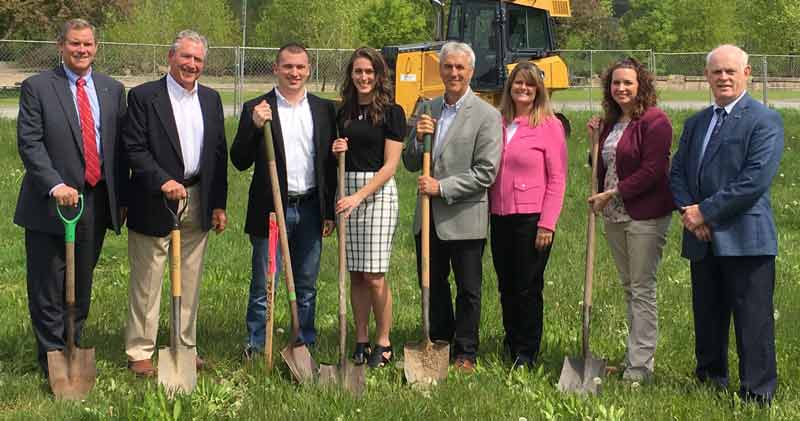 Eight people stand by as if they were about to dig