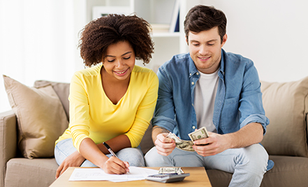man and woman on couch doing bills