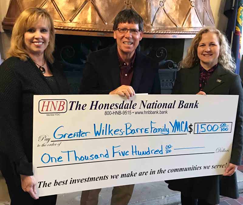 Three people hold a big check