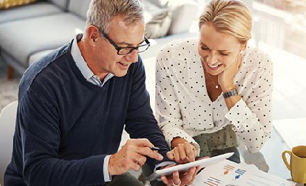 Couple looking over their money market account on a tablet.