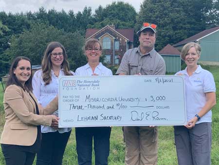 five people holding a check donation for Misericordia University and Lehman Sanctuary