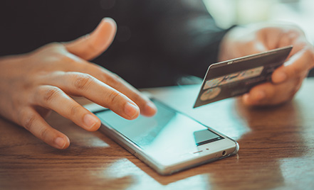 man paying on mobile phone with credit card