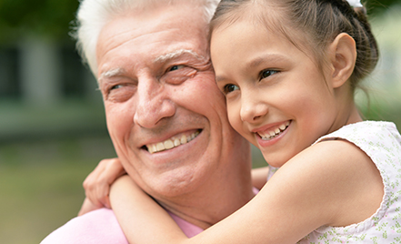 grandfather and granddaughter smiling